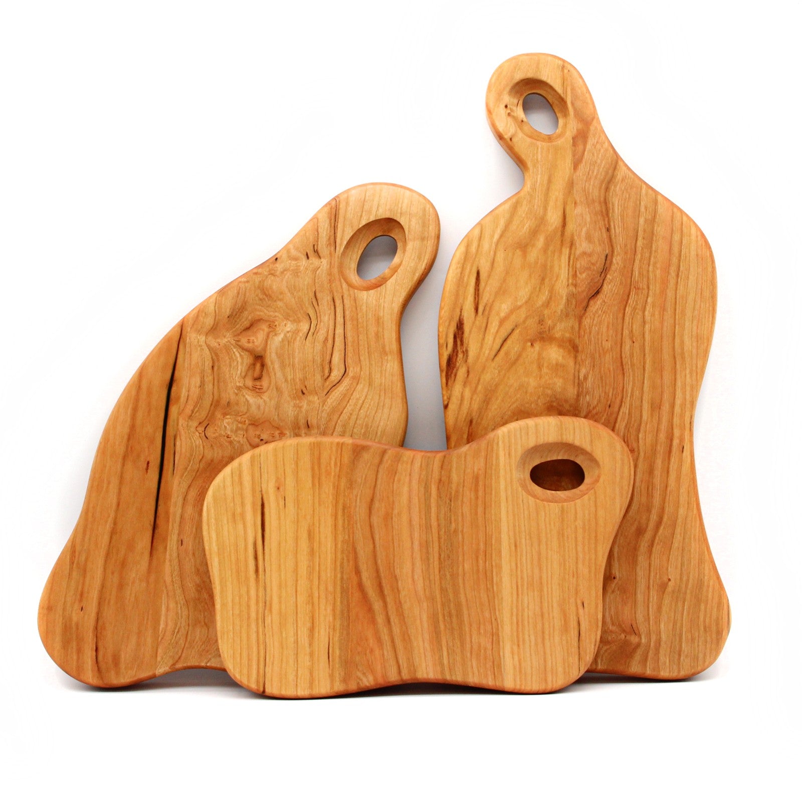 Three coordinated wooden serving boards with organic shapes and round handles
