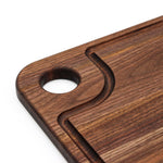 Close-up of the walnut thumb-hole board handle and curved juice groove.