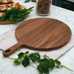 Walnut round pizza paddle in a kitchen setting.