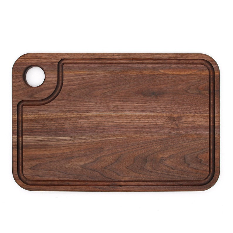Walnut thumb-hole cutting board with specialty juice groove, top view.