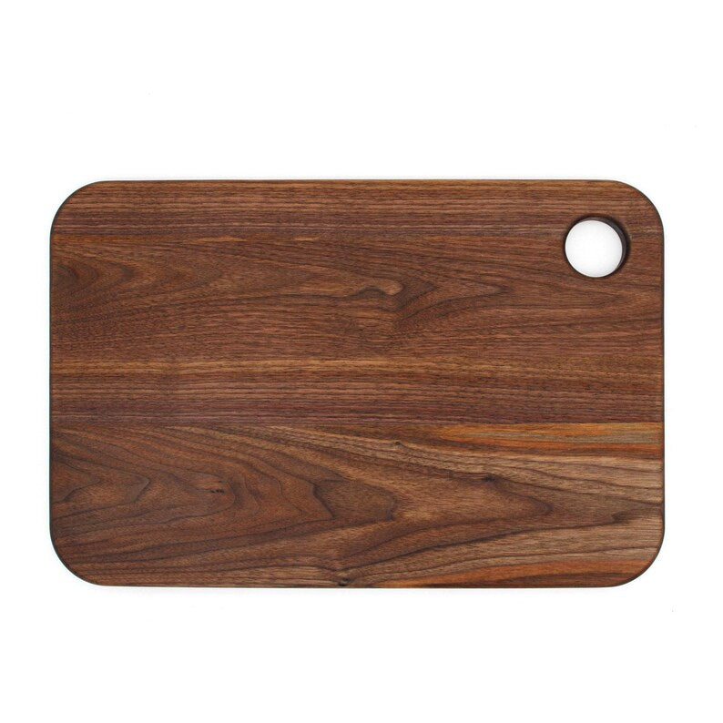 Walnut thumb-hole cutting board plain reverse face, top view.