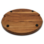 Walnut 18-inch thick round cutting board underside with four black rubber feet, angled view.