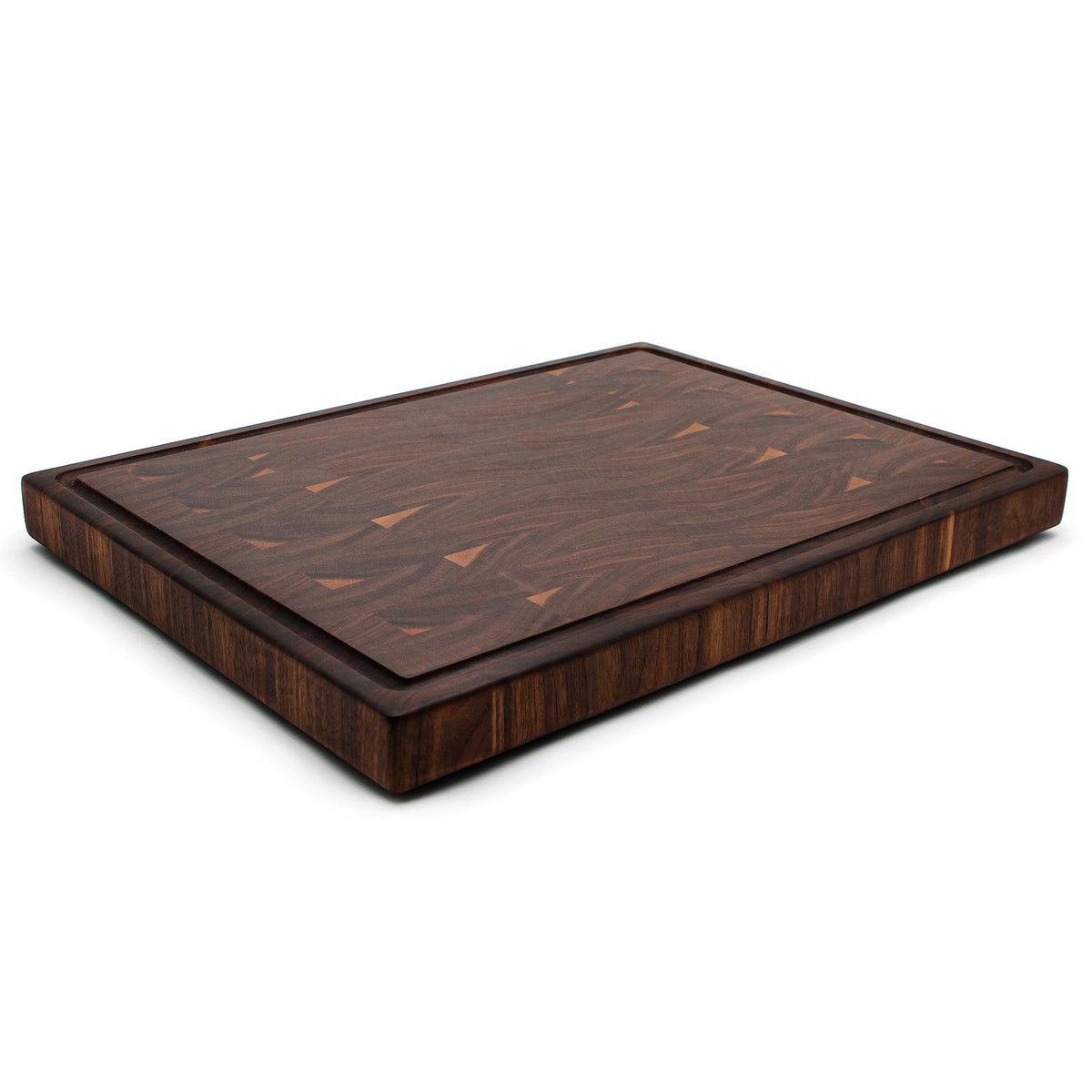 Walnut 20 × 15 end-grain cutting board with juice groove, low angled view showing its thickness.