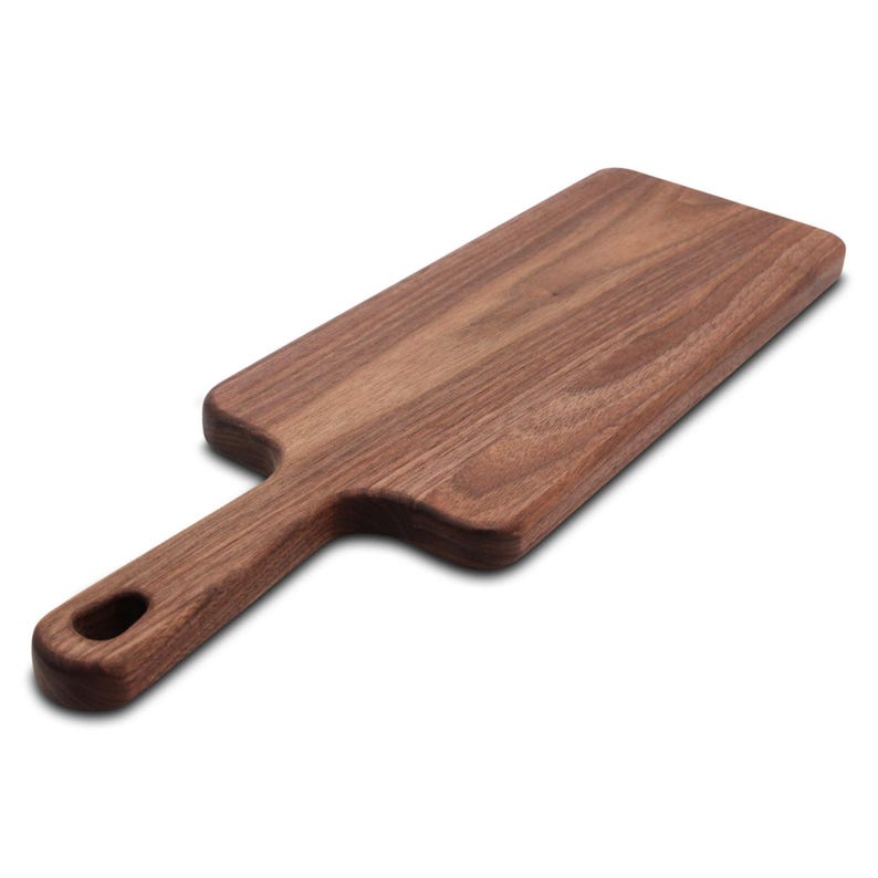 Walnut narrow paddle serving board shown at an angle, highlighting the wood grain and built-in handle.