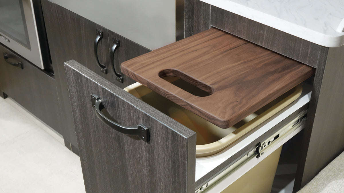 Walnut Pottery Barn bread board pulled out from the cabinetry in an Airstream kitchen