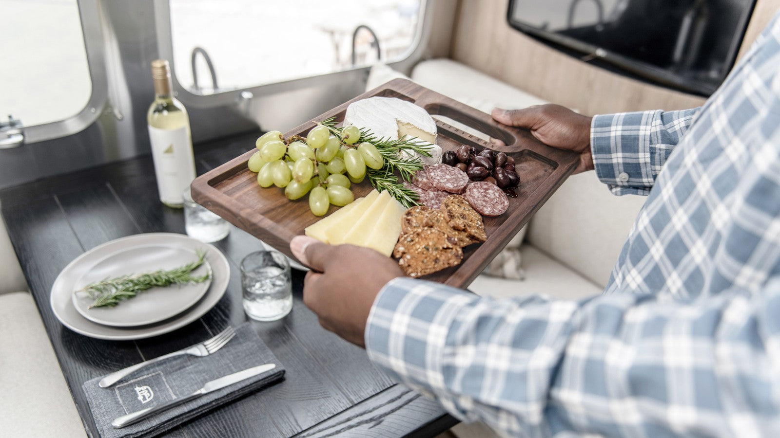 Walnut serving board with cheese and fruit in an Airstream × Pottery Barn kitchen