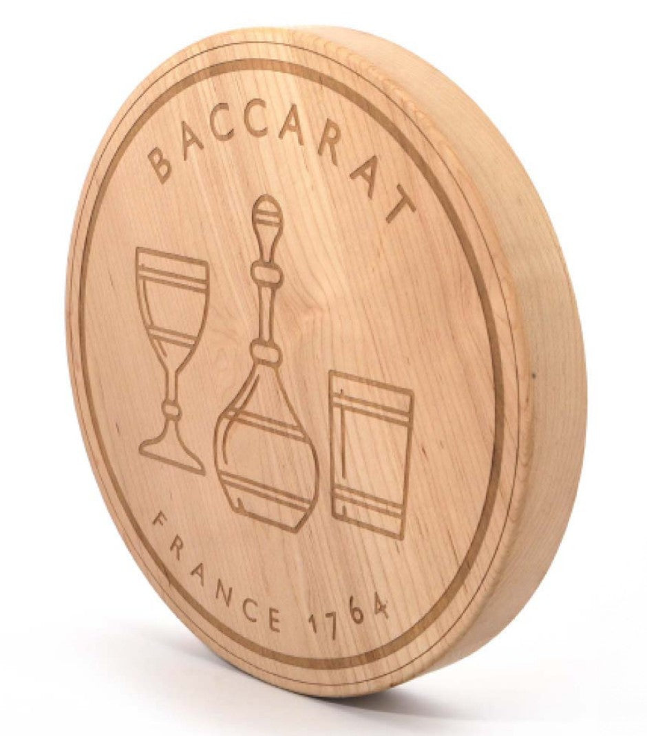 Round wooden piece with engraved Baccarat lettering and glassware artwork